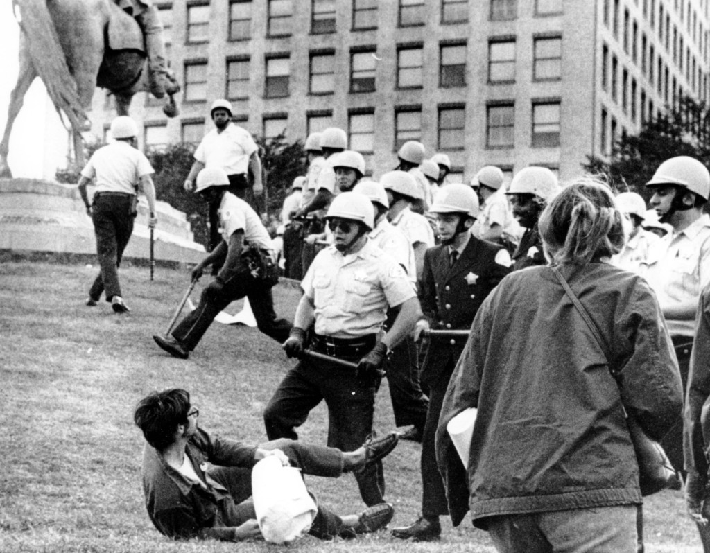 This photo shows Chicago policemen with nightsticks in hand confronting a demonstrator on the ground in Grant Park, Chicago, on August 26, 1968. The police force converged at Grant Park when protesters opposing the Vietnam War climbed on the statue of civil war Gen. John Logan. (AP Photo)